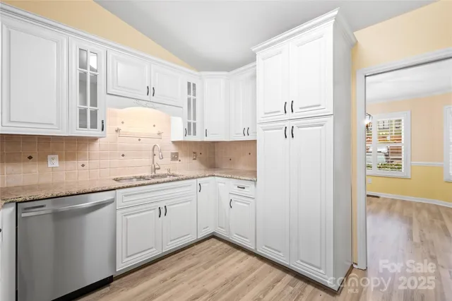 a kitchen with granite countertop white cabinets and white appliances