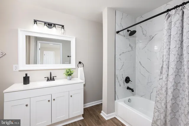 a bathroom with a bathtub sink vanity and mirror