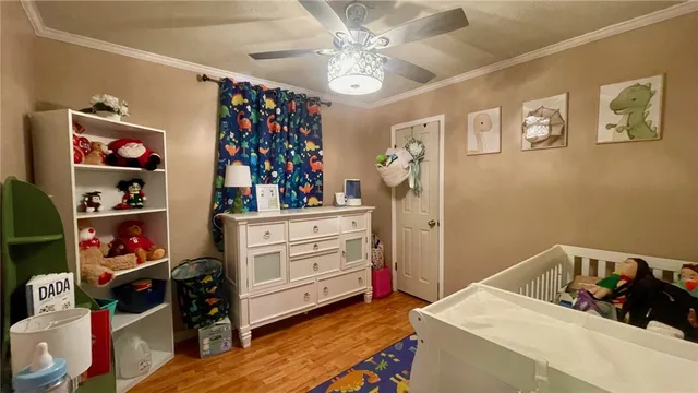 a bedroom with a bed and a flat tv screen on dresser