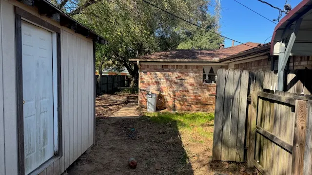 a view of backyard with wooden fence and trees