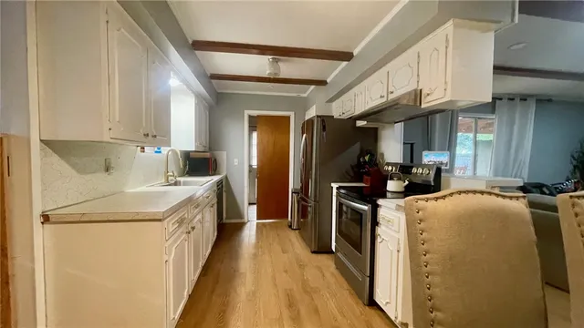 a kitchen with stainless steel appliances a stove a sink a microwave and refrigerator