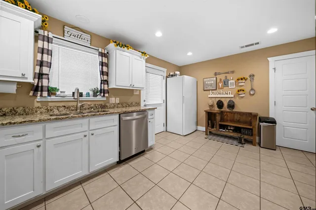a kitchen with granite countertop a refrigerator stove and microwave