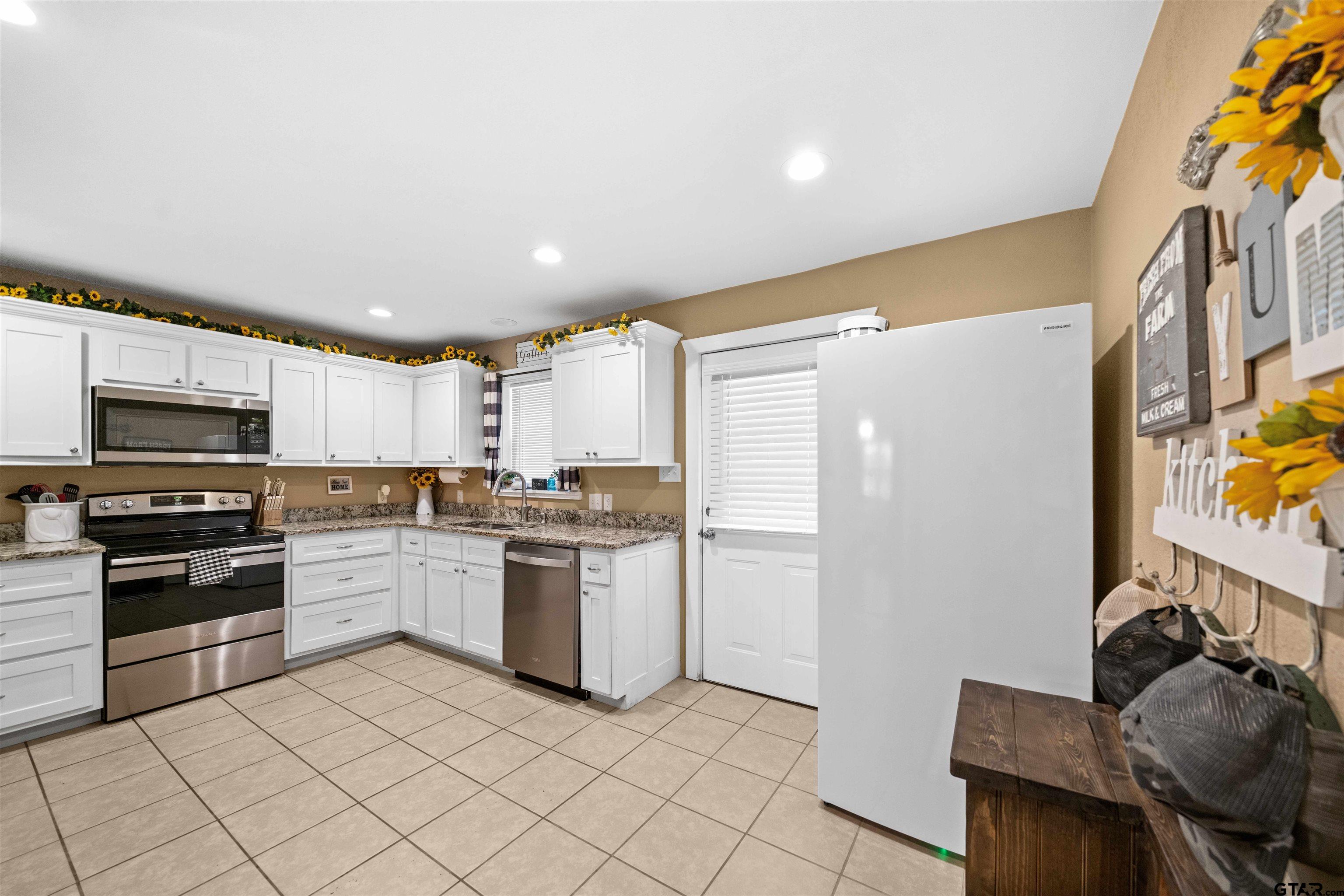 8781 Farm To Market 59 Athens, TX 75751 - Photo 15 of 37 a kitchen with stainless steel appliances granite countertop a refrigerator and a stove top oven