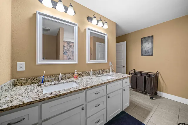 a bathroom with a granite countertop sink and a mirror