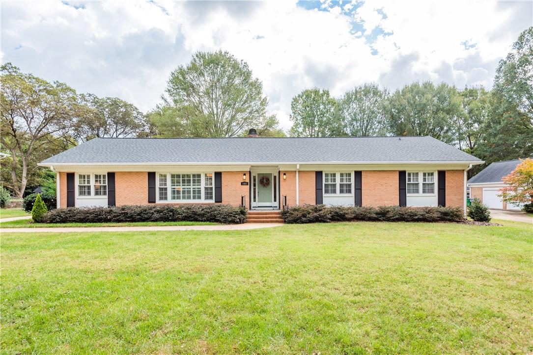 a front view of a house with a garden and trees