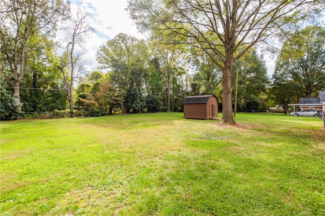 1001 Lansdowne Road Charlotte, NC 28270 - Photo 14 of 17 a backyard of a house with lots of green space
