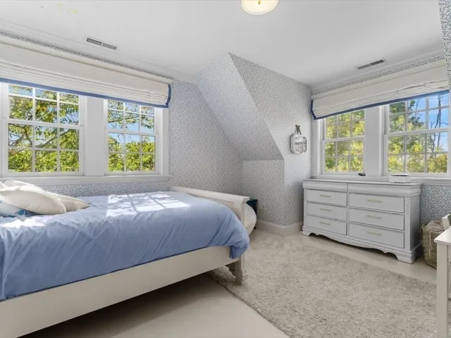 a bed sitting in a bedroom next to a window