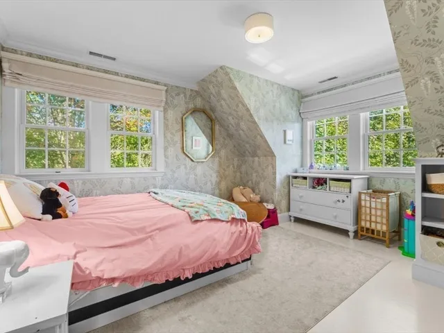 a bedroom with a bed a window and dresser