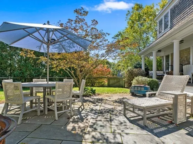 a view of a patio with a table and chairs under an umbrella