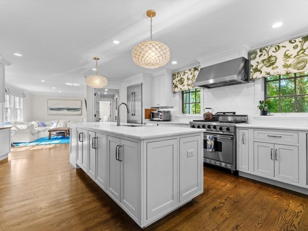 25 Forest Street Manchester, MA 01944 - Photo 8 of 34 a kitchen with stainless steel appliances granite countertop a stove a sink dishwasher and white cabinets with wooden floor