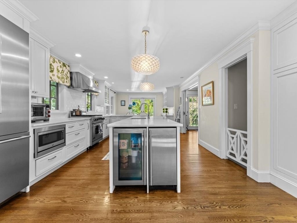 25 Forest Street Manchester, MA 01944 - Photo 9 of 34 a kitchen with stainless steel appliances kitchen island granite countertop a stove top oven a sink and a refrigerator
