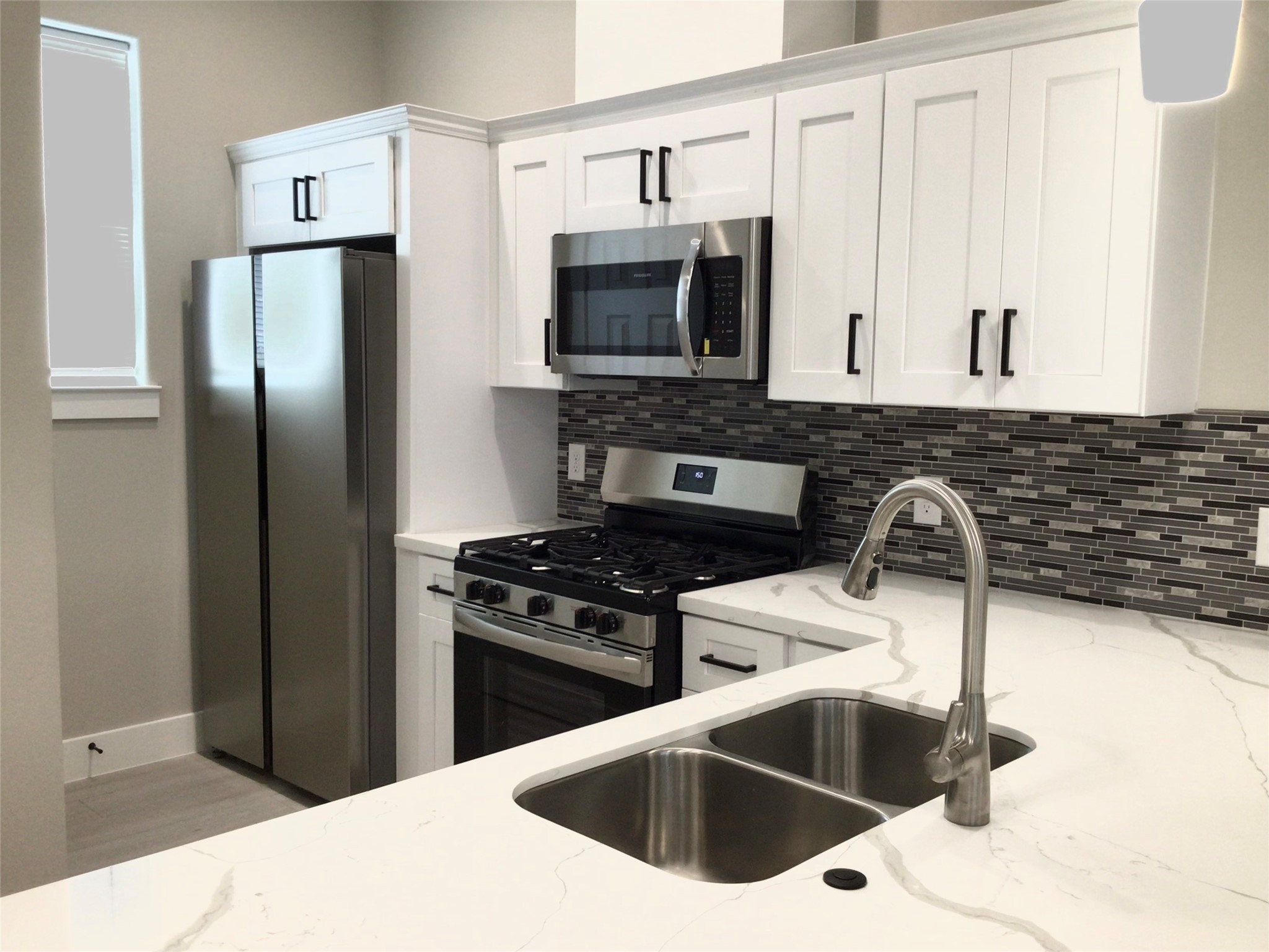 2109 Marnel Road, Unit B Houston, TX 77055 - Photo 11 of 46 a kitchen with stainless steel appliances granite countertop a stove a refrigerator and a sink