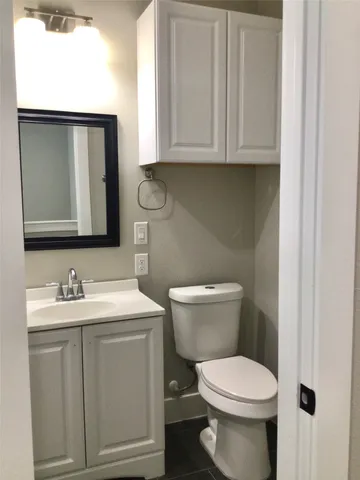 a white toilet sitting next to a bathroom sink
