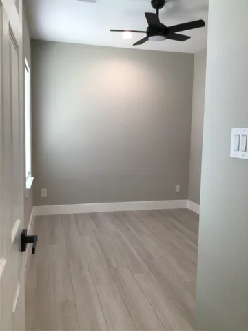 a view of an empty room with window and closet area