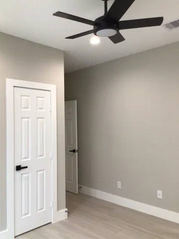a view of a hallway with wooden floor and a cabinet