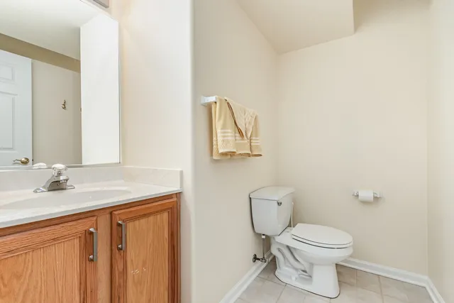 a bathroom with a toilet sink vanity and mirror