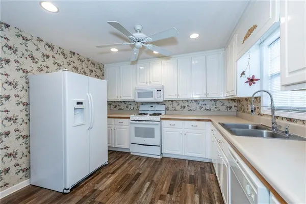 a kitchen with a sink cabinets stainless steel appliances and a window