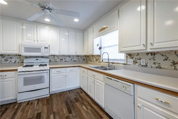 a kitchen with kitchen island white cabinets appliances and a sink