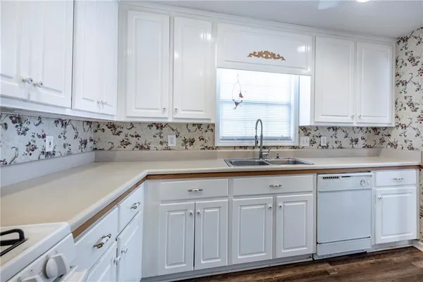 a kitchen with white cabinets and sink