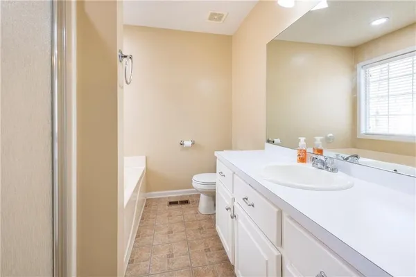 a bathroom with a sink a toilet and a window