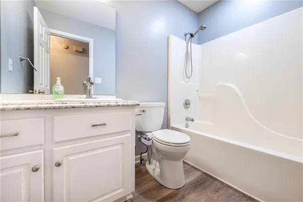 a bathroom with a granite countertop sink toilet and shower