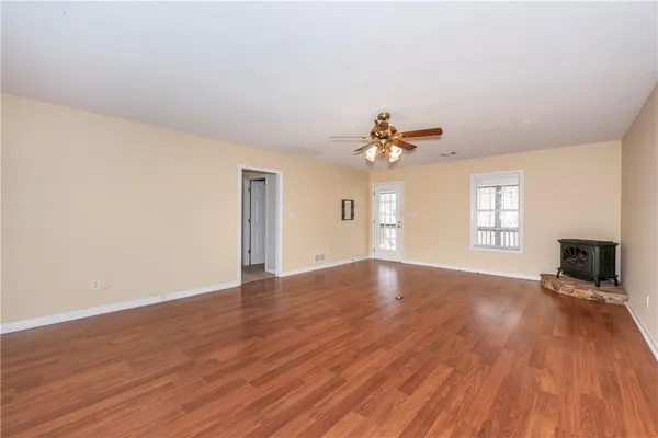 a view of empty room with wooden floor and fireplace
