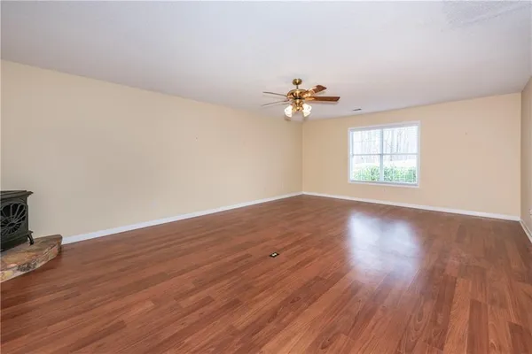 an empty room with wooden floor and window