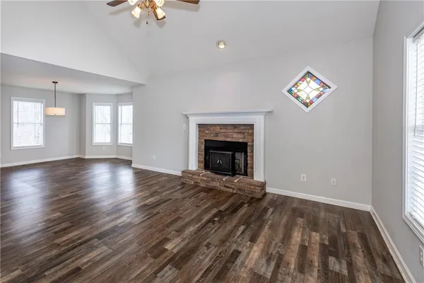 wooden floor fireplace and windows in an empty room