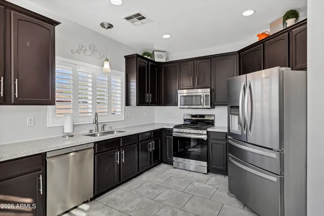 a kitchen with kitchen island granite countertop stainless steel appliances and sink