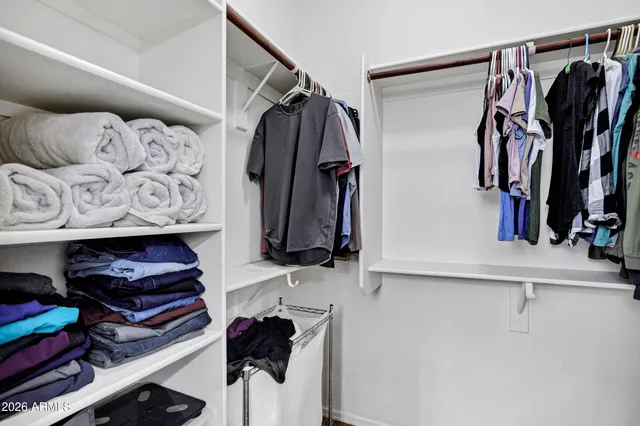 a view of walk in closet with clothes and shoes