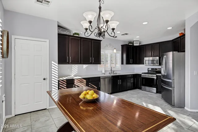 a kitchen with a refrigerator a stove a microwave and a dining table with wooden floor