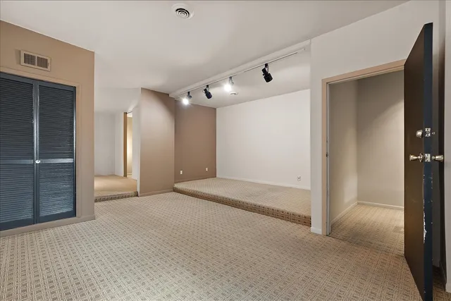 a view of a big room with closet and chandelier