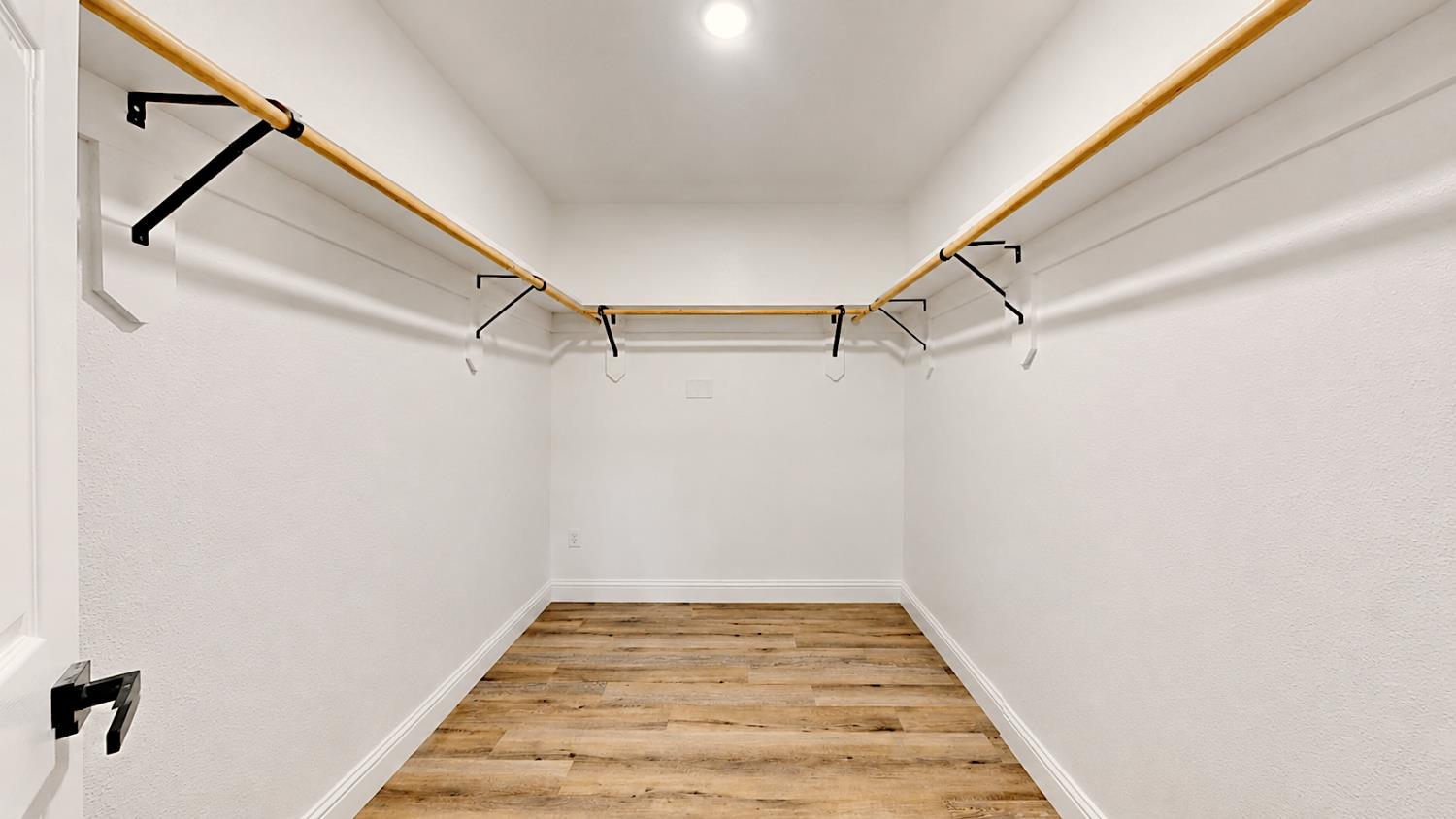 4728 Zorro Road La Grange, CA 95329 - Photo 41 of 56 Master Bedroom Walk in Closet. Neutral white walls, wood-finish flooring, recessed ceiling lighting, and matte black hardware on the door and closet supports