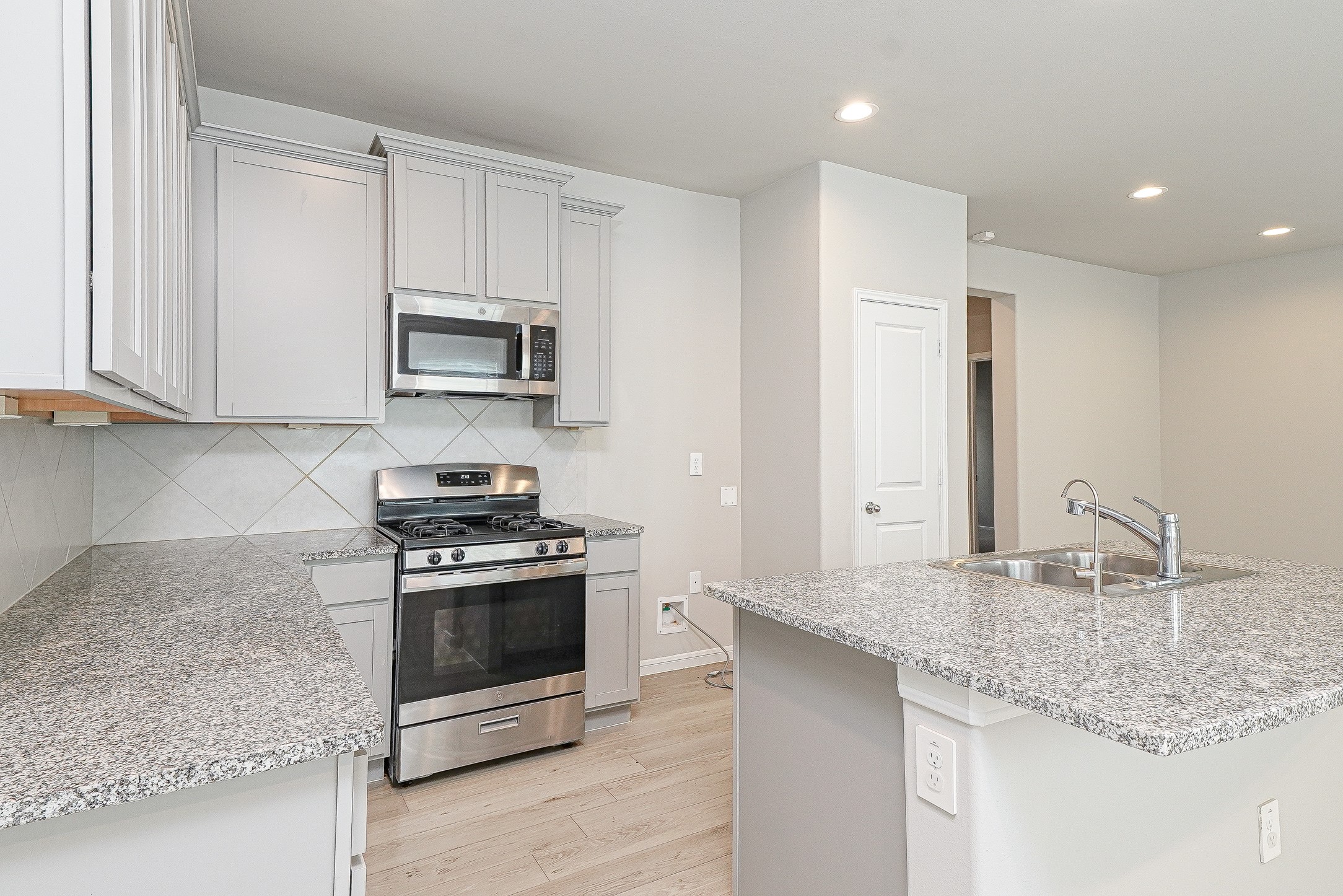 9254 Sea Gdn Street Houston, TX 77034 - Photo 9 of 33 a kitchen with stainless steel appliances granite countertop a stove a sink and a microwave