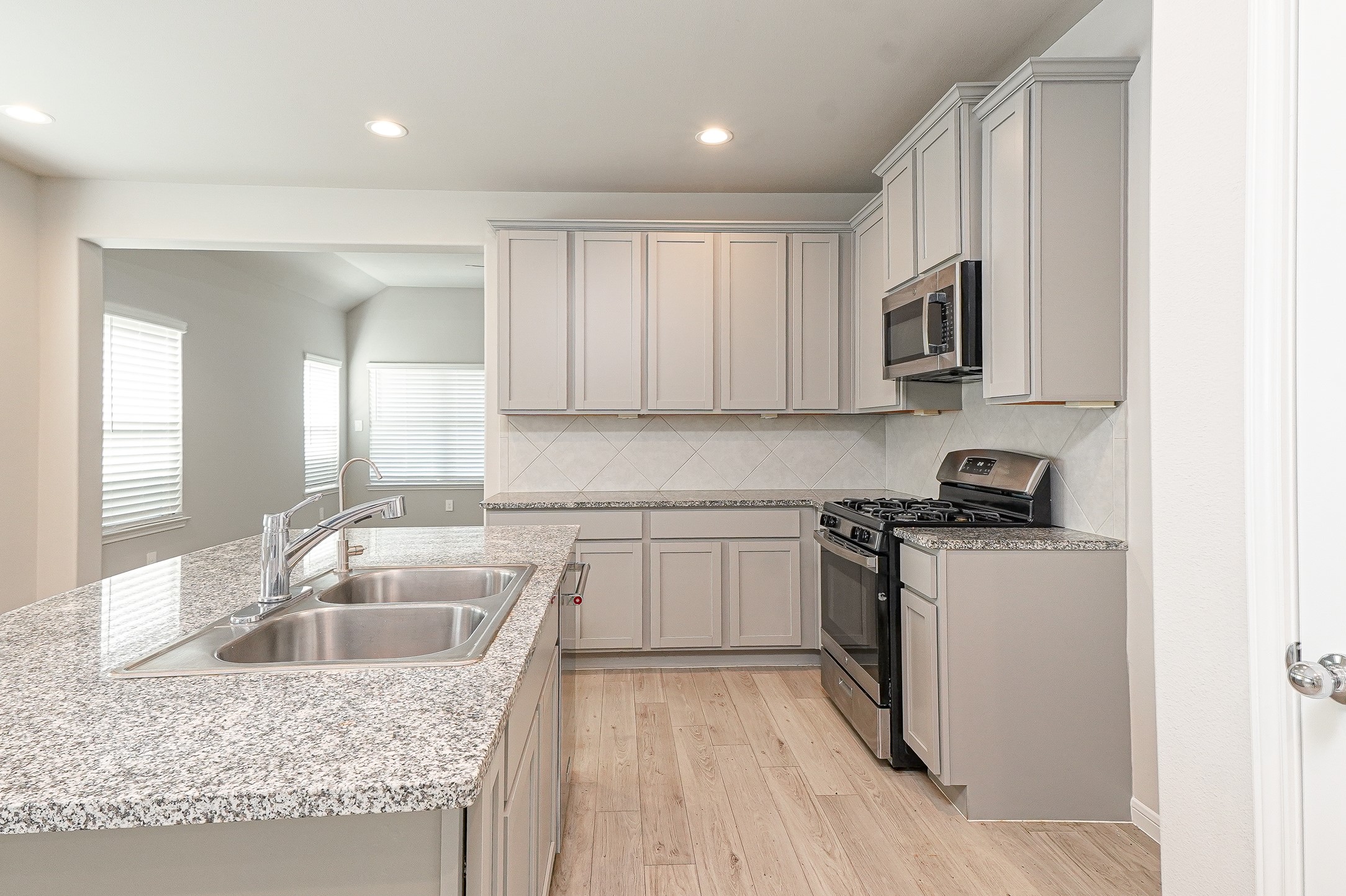 9254 Sea Gdn Street Houston, TX 77034 - Photo 10 of 33 a kitchen with granite countertop a sink stove and cabinets