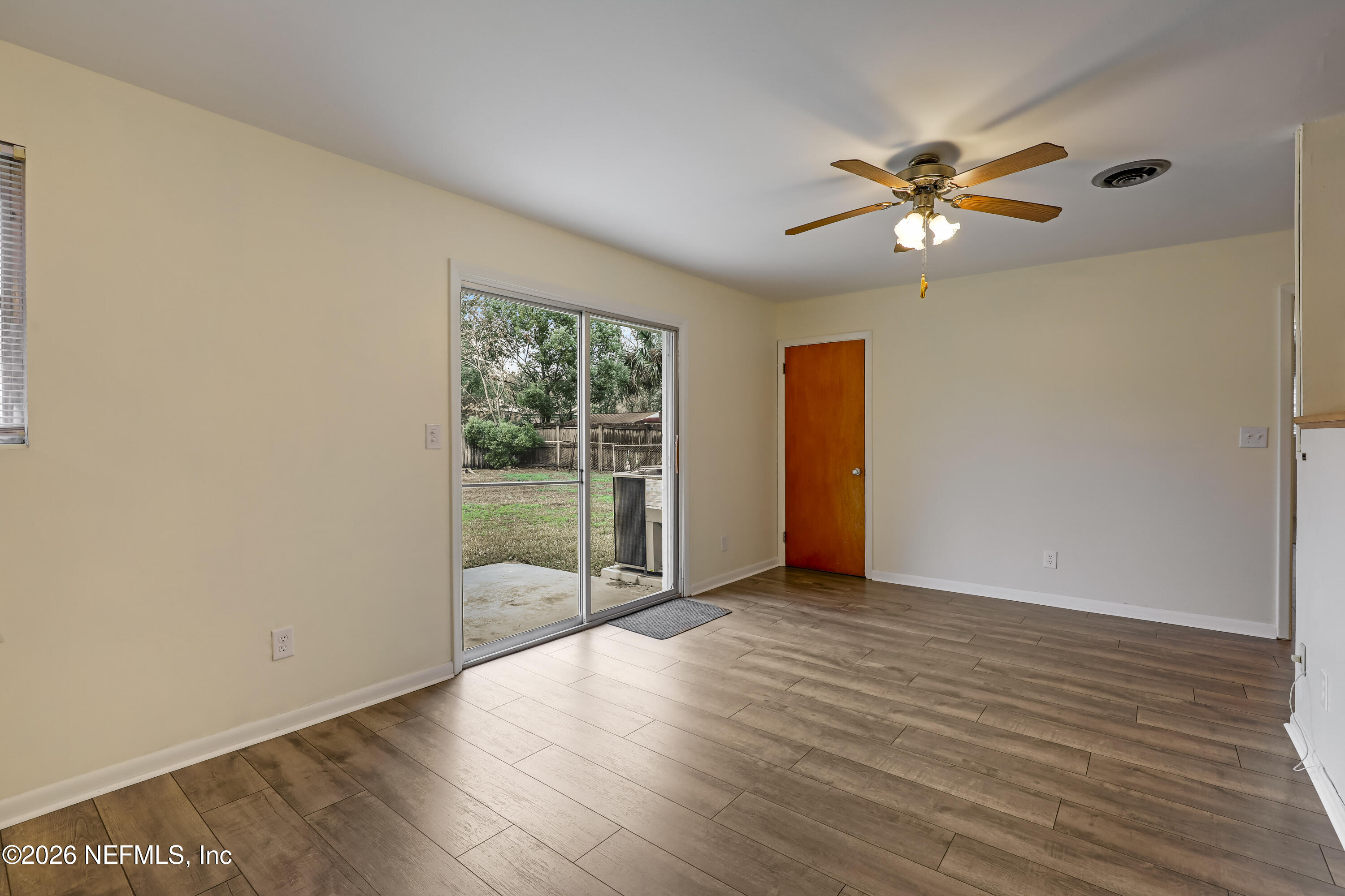 3944 Rodby Drive Jacksonville, FL 32210 - Photo 24 of 40 an empty room with wooden floor fan and windows