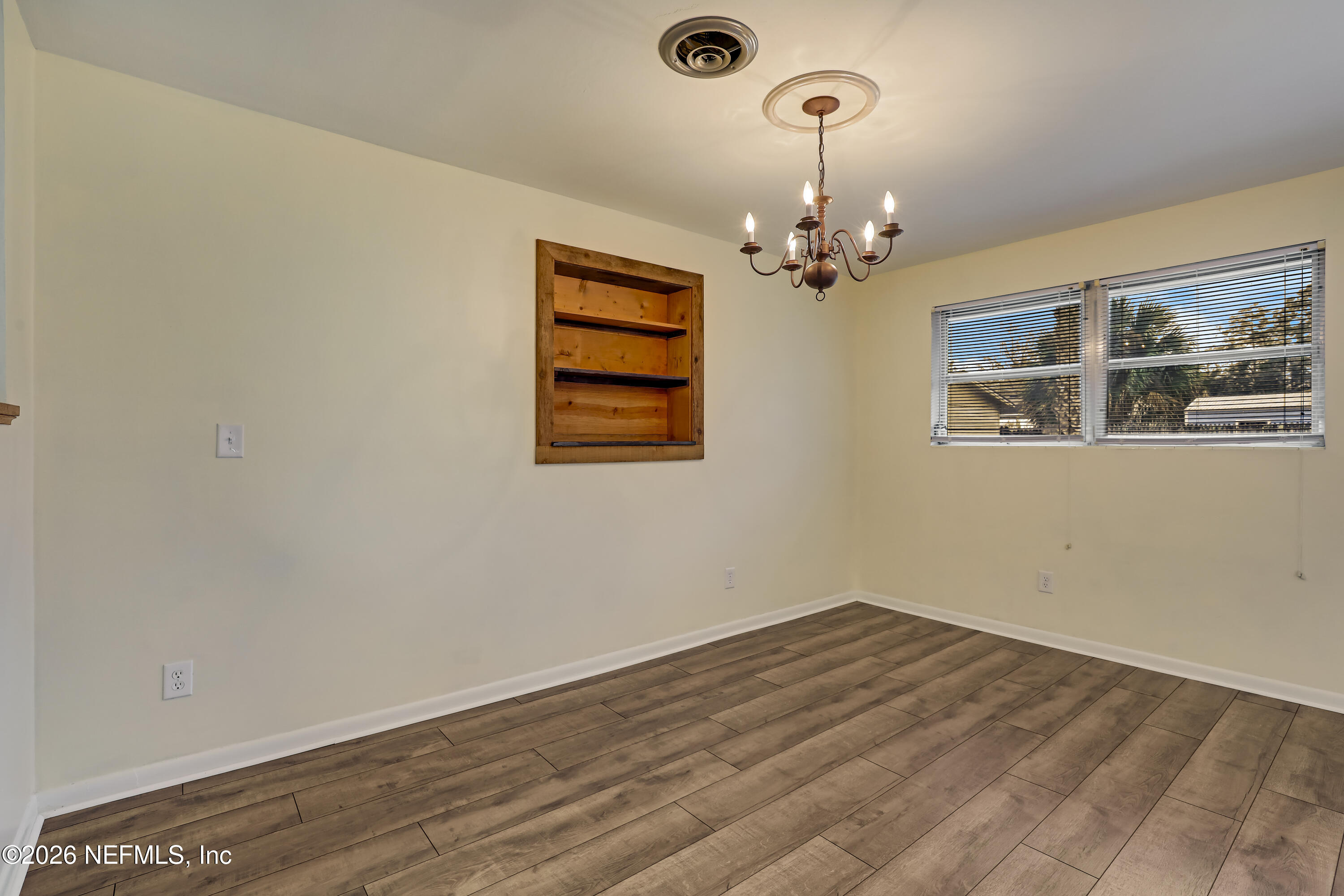 3944 Rodby Drive Jacksonville, FL 32210 - Photo 26 of 40 a view of a room with wooden floor chandelier and window