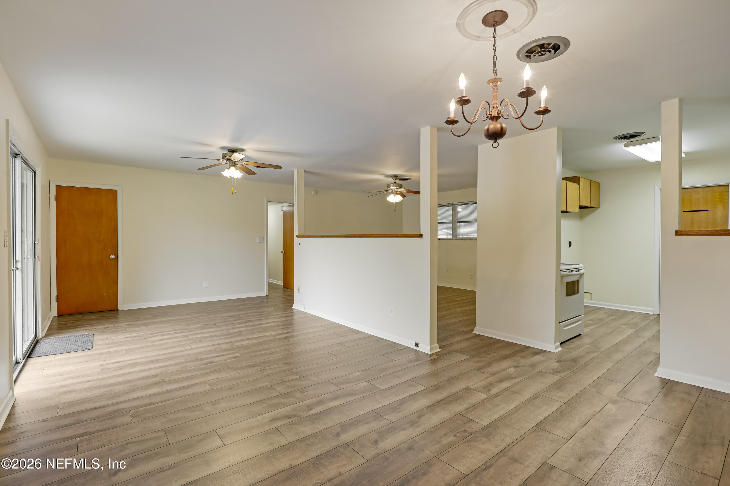3944 Rodby Drive Jacksonville, FL 32210 - Photo 4 of 40 wooden floor in an empty room with a chandelier fan