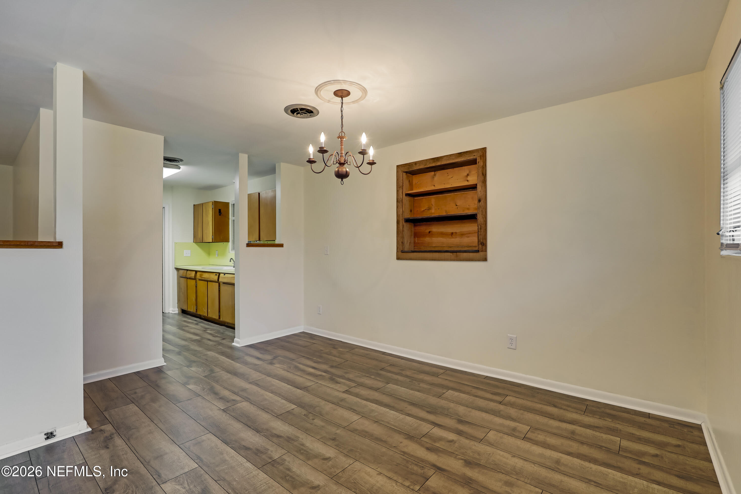 3944 Rodby Drive Jacksonville, FL 32210 - Photo 5 of 40 wooden floor in an empty room with a window
