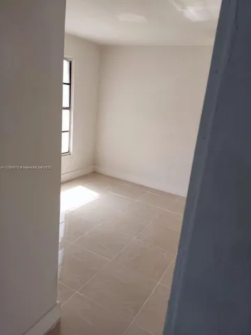 an empty room with windows and entrance