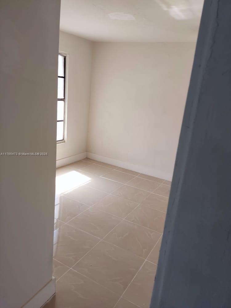 900 Northwest 80th Street Miami, FL 33150 - Photo 9 of 11 an empty room with windows and entrance