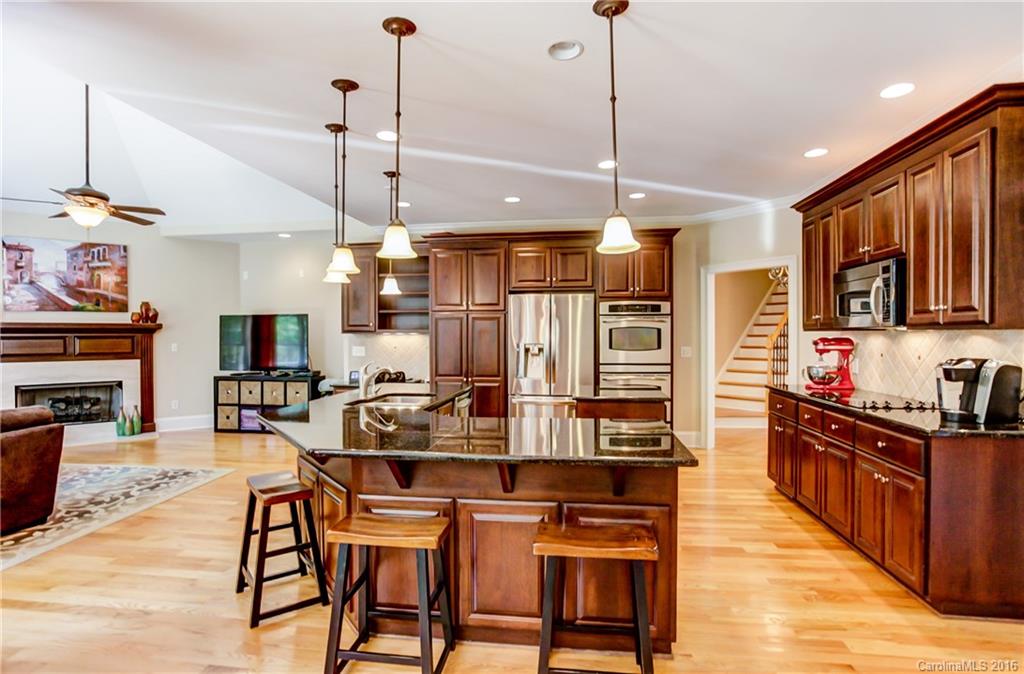 5908 Johnson Road Clover, SC 29710 - Photo 6 of 23 a kitchen with stainless steel appliances kitchen island granite countertop a refrigerator a stove top oven a sink dishwasher and a dining table with wooden floor