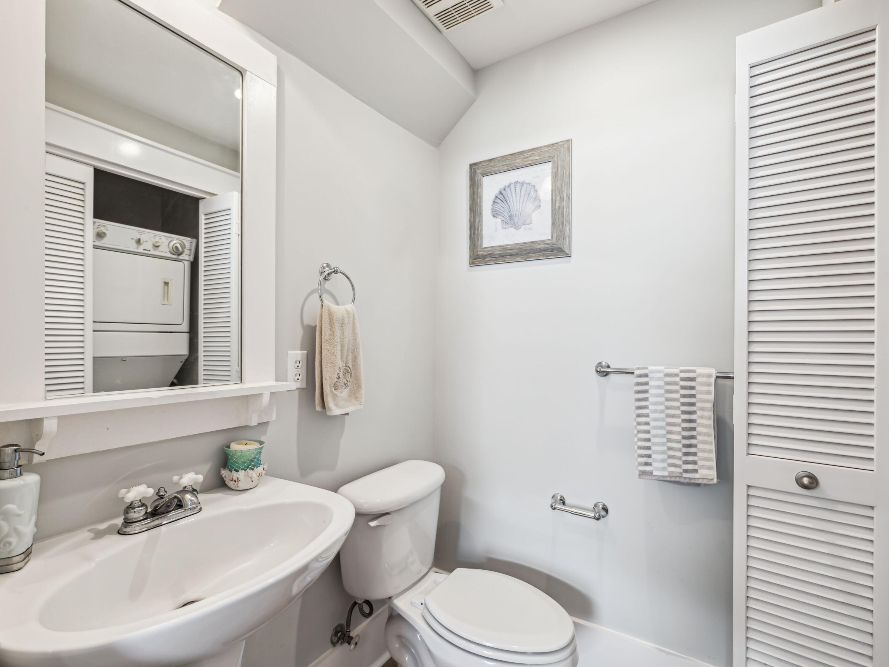 198 Somerset Bridge Road, Unit 103 Santa Rosa Beach, FL 32459 - Photo 21 of 39 a white toilet sitting next to a bathroom sink