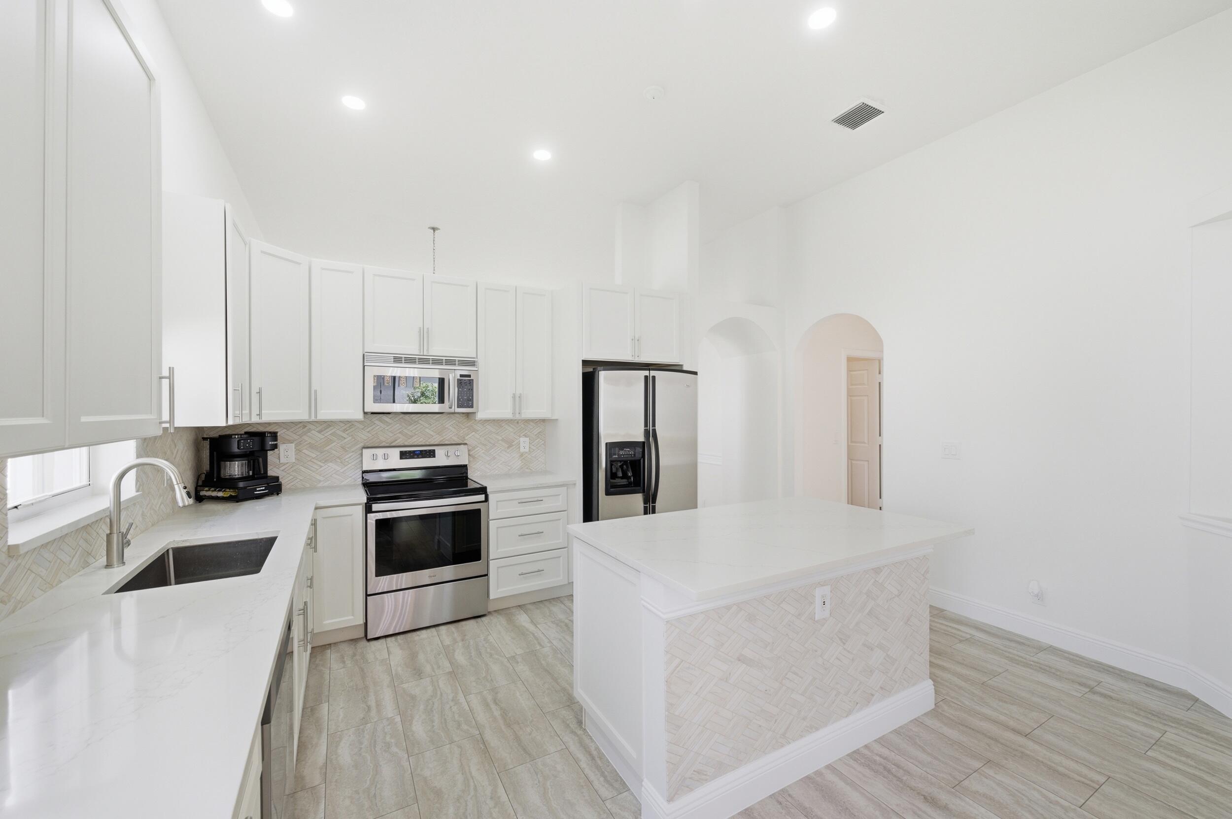 8534 Vía D Oro Boca Raton, FL 33433 - Photo 13 of 34 a kitchen with granite countertop a stove top oven sink and cabinets