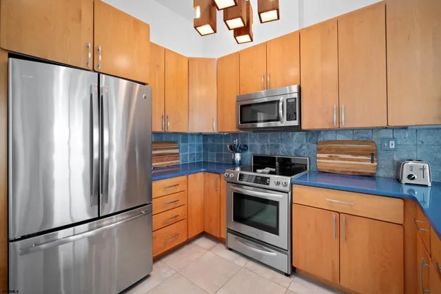 a kitchen with stainless steel appliances granite countertop a refrigerator a stove a sink and a microwave