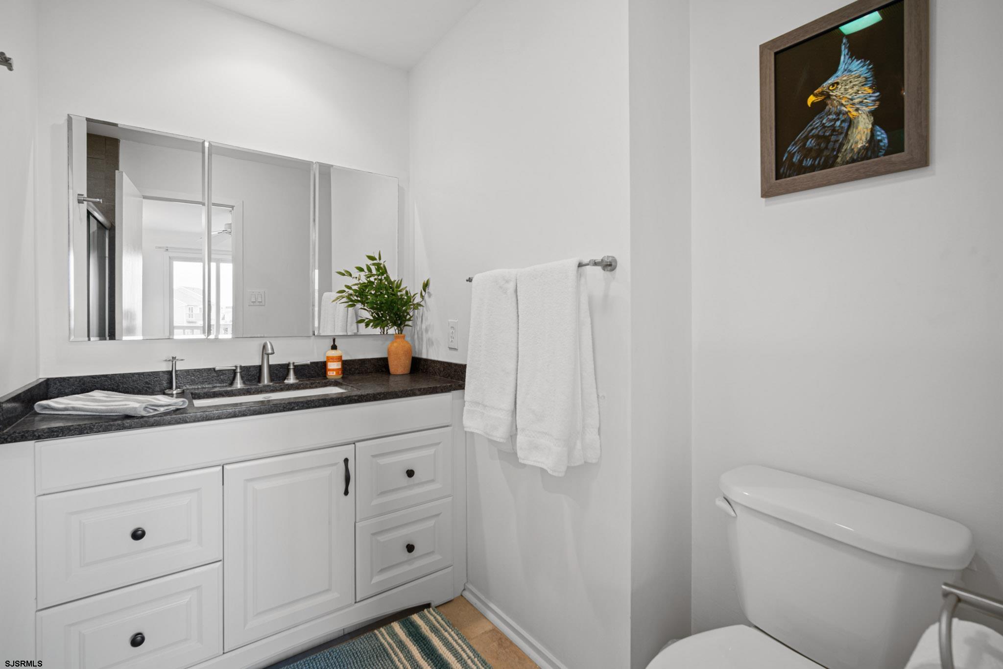 45 Coquille, Unit 45 Brigantine, NJ 08203 - Photo 24 of 30 a bathroom with a toilet sink and mirror