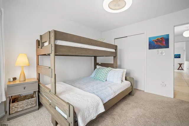 a bedroom with a bed and a lamp on dresser