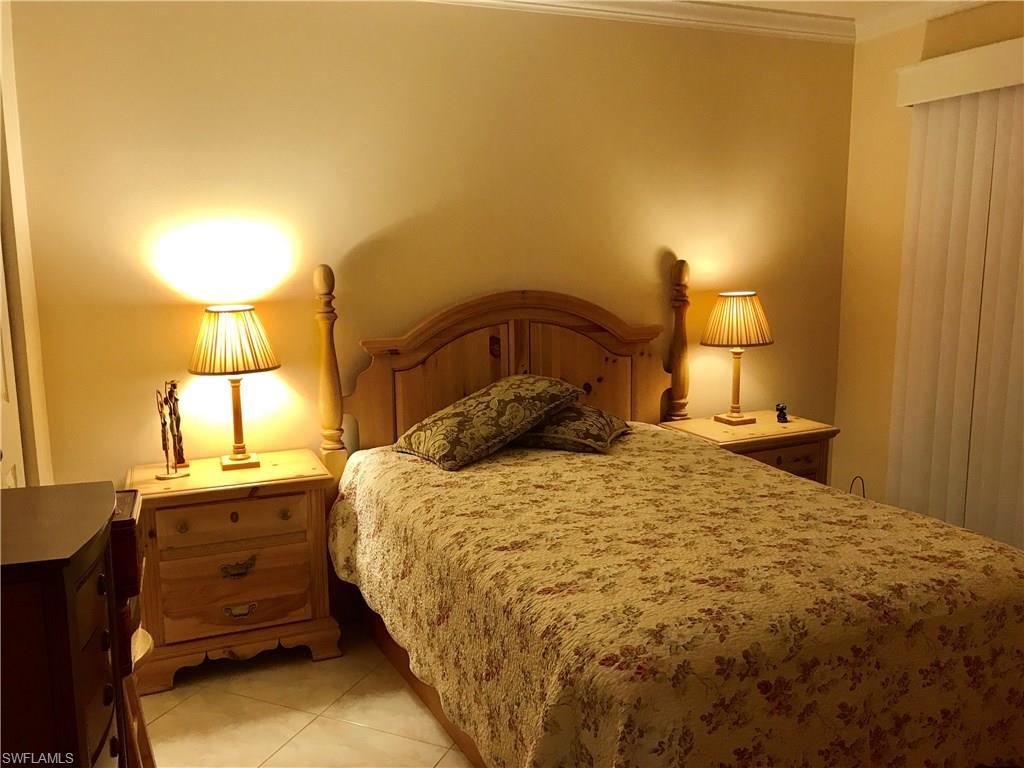 4256 31st Place Southwest Naples, FL 34116 - Photo 14 of 20 a bedroom with a bed and a lamp