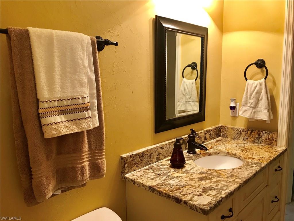 4256 31st Place Southwest Naples, FL 34116 - Photo 15 of 20 a bathroom with a granite countertop sink and mirror with bathtub