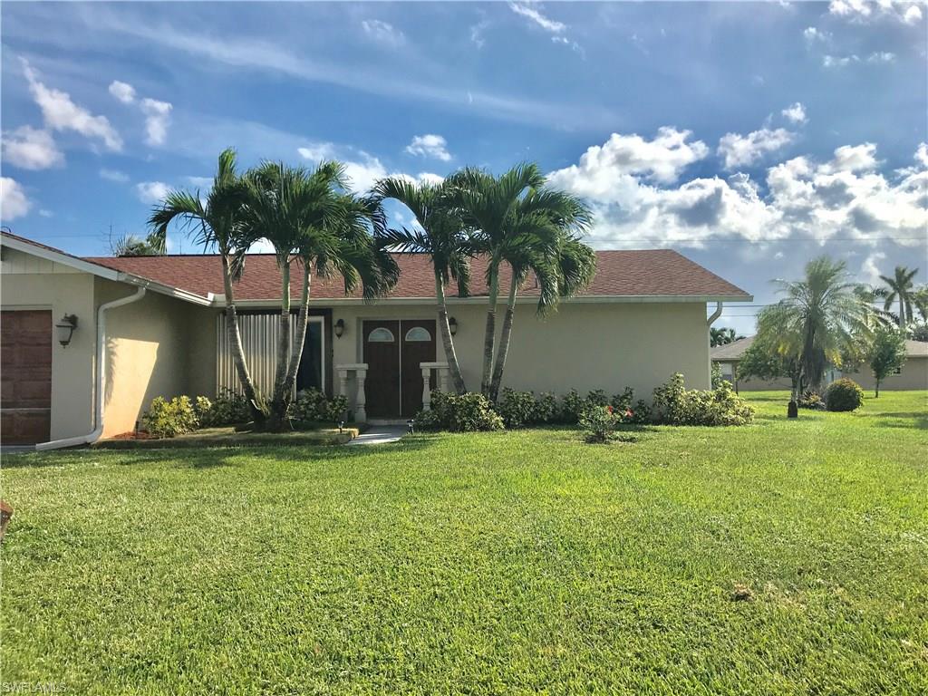 4256 31st Place Southwest Naples, FL 34116 - Photo 3 of 20 a view of a house with a yard and a garage